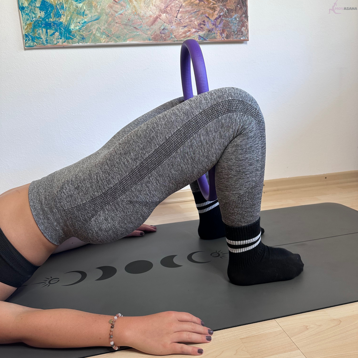 Pilates-Ring des Movasana Pilates Set zwischen den Knien in der Schulterbrücke