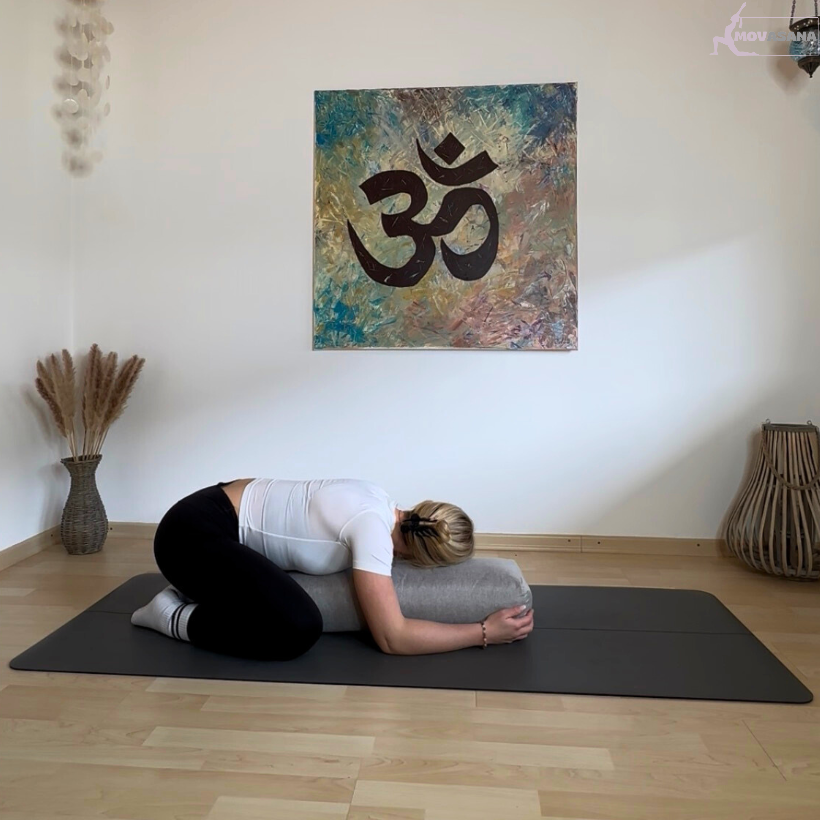 Frau in der Kindeshaltung mit dem Oberkörper auf dem Movasana Yoga Bolster