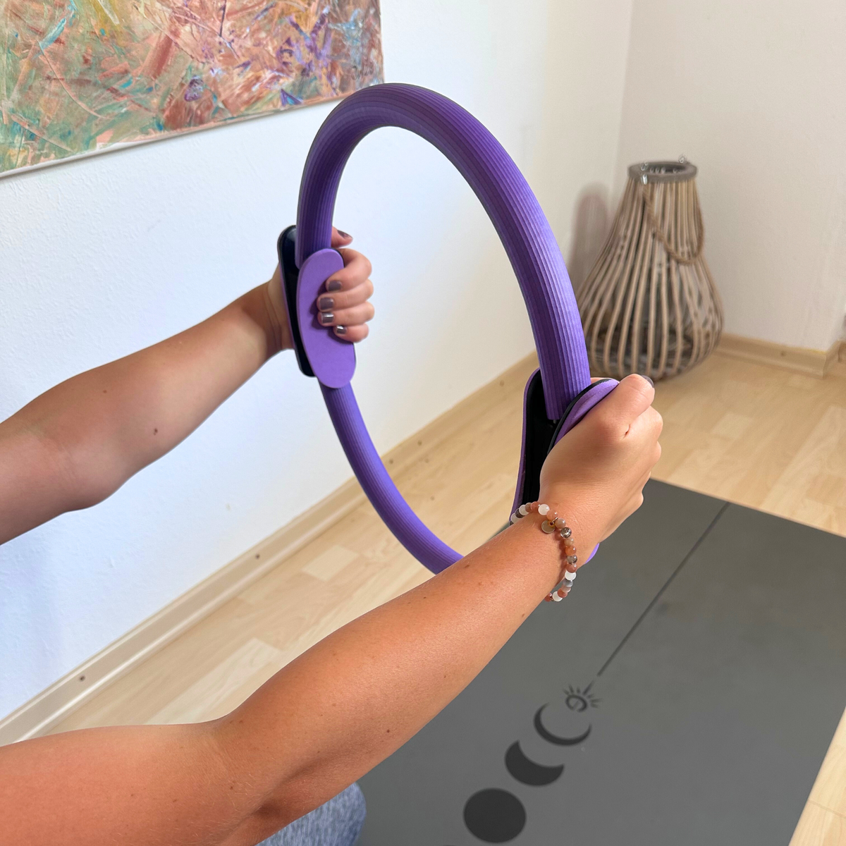 Pilates-Ring des Movasana Pilates Set wird mit beiden Händen vor dem Körper zusammengedrückt