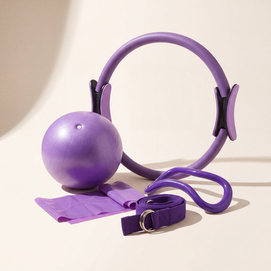 Movasana Pilates Set: Pilatesring, Gymnastikball, Widerstandsband, Yogagurt und Stretchband auf nahtlosem Studiogrund